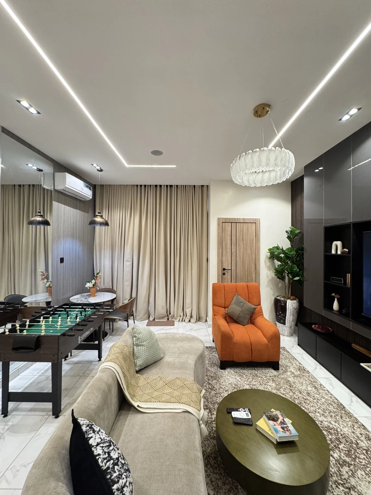 Veyra — living room with curved sofa and orange armchair, view 215